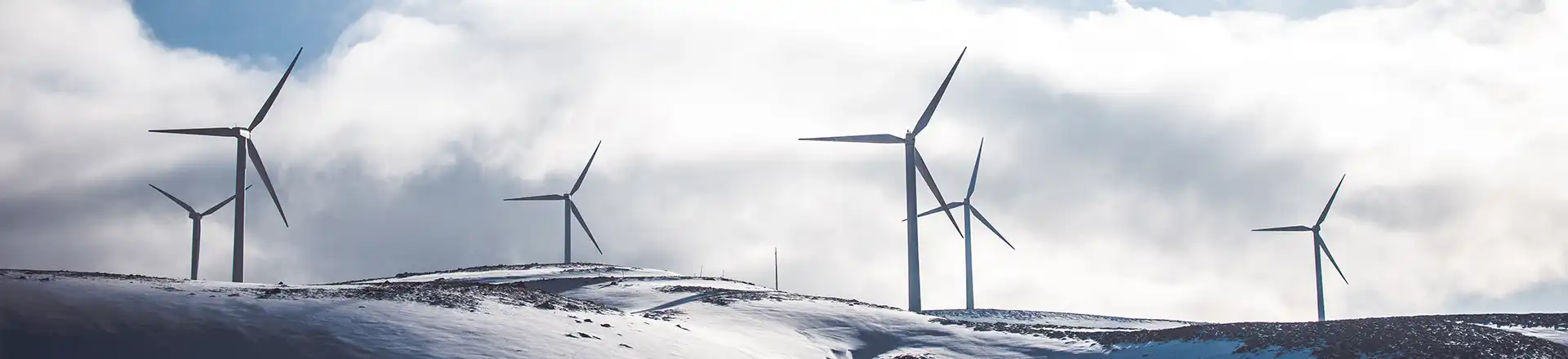 wind turbines on snow covered hills