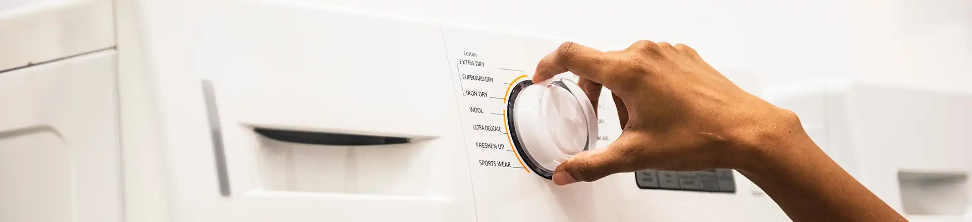 hand turning dial on washing machine