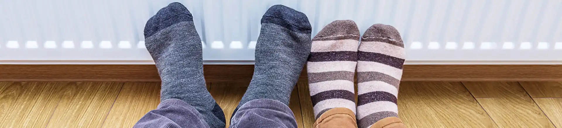 feet in socks in front of radiator heater