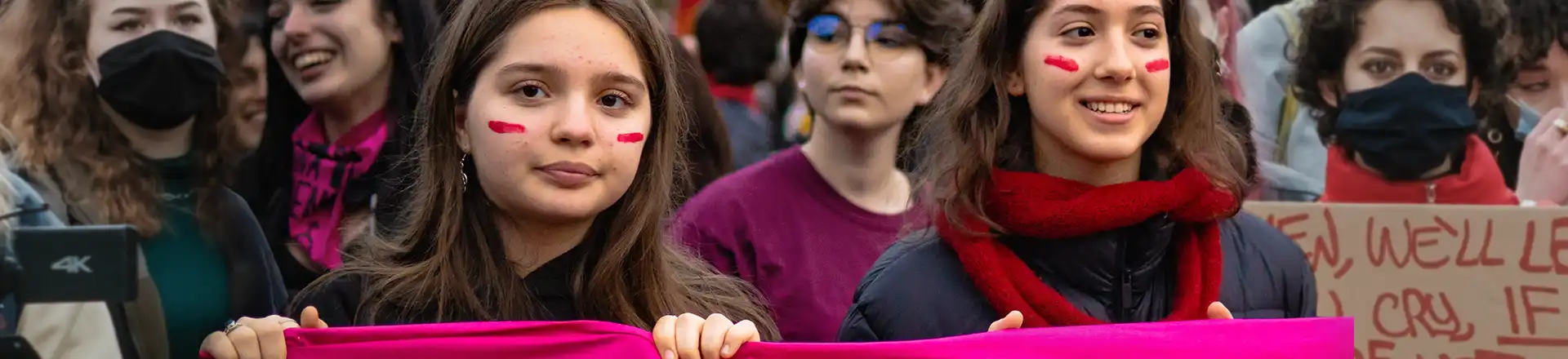 women holding pink banner